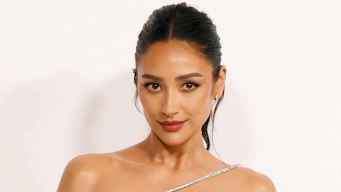 Shay Mitchell poses in an off-the-shoulder dress and a slicked back up-do.